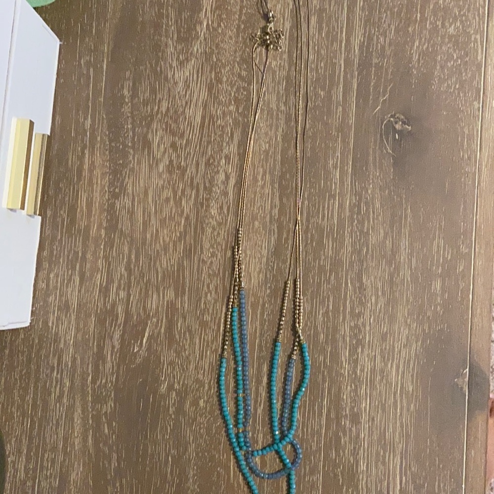 Turquoise, blue, and gold beaded layered necklace.